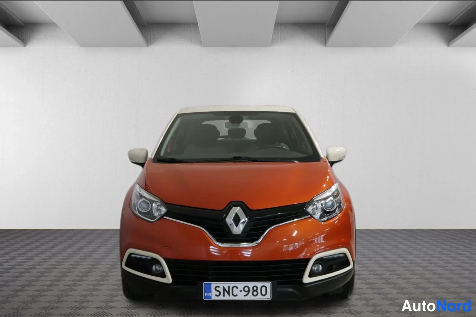 Edestä: Renault Captur suoraan edestä kuvattuna, oranssi kori ja valkoinen katto, rekisteritunnus.