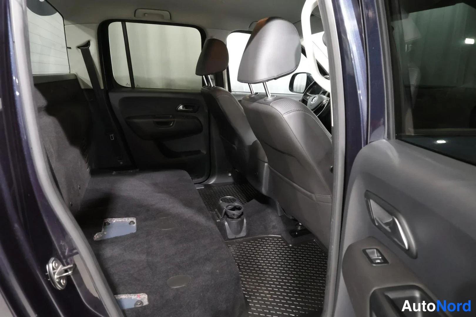 Takaistuimet: Autoauton takaistuimen selkänojat on taitettu alas tasaiseksi lastauspinnaksi; tummanharmaa sisusta ja takiovin auki.