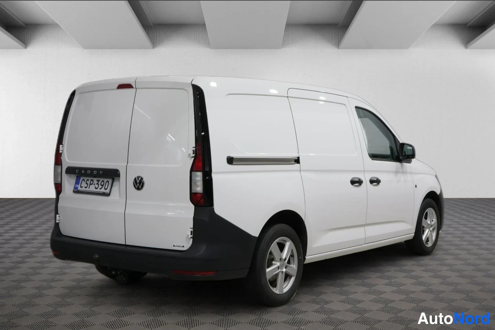 Takaviisto: Valkoisen Volkswagen Caddy -pakettiauton taka- ja kylkinäkymä, kahlet takapari-ovet ja rekisteritunnus.
