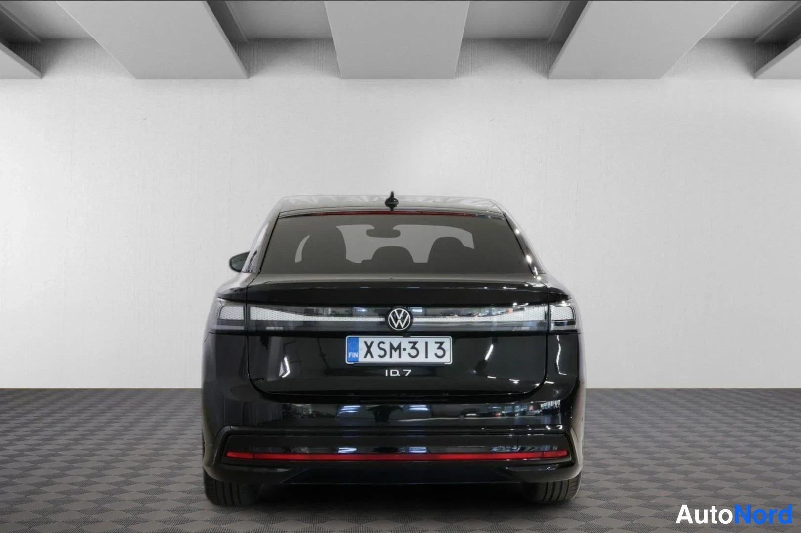 Takaa: Mustan Volkswagen ID.7:n suora takakuva studiovalkoisella taustalla, rekisteritunnus.