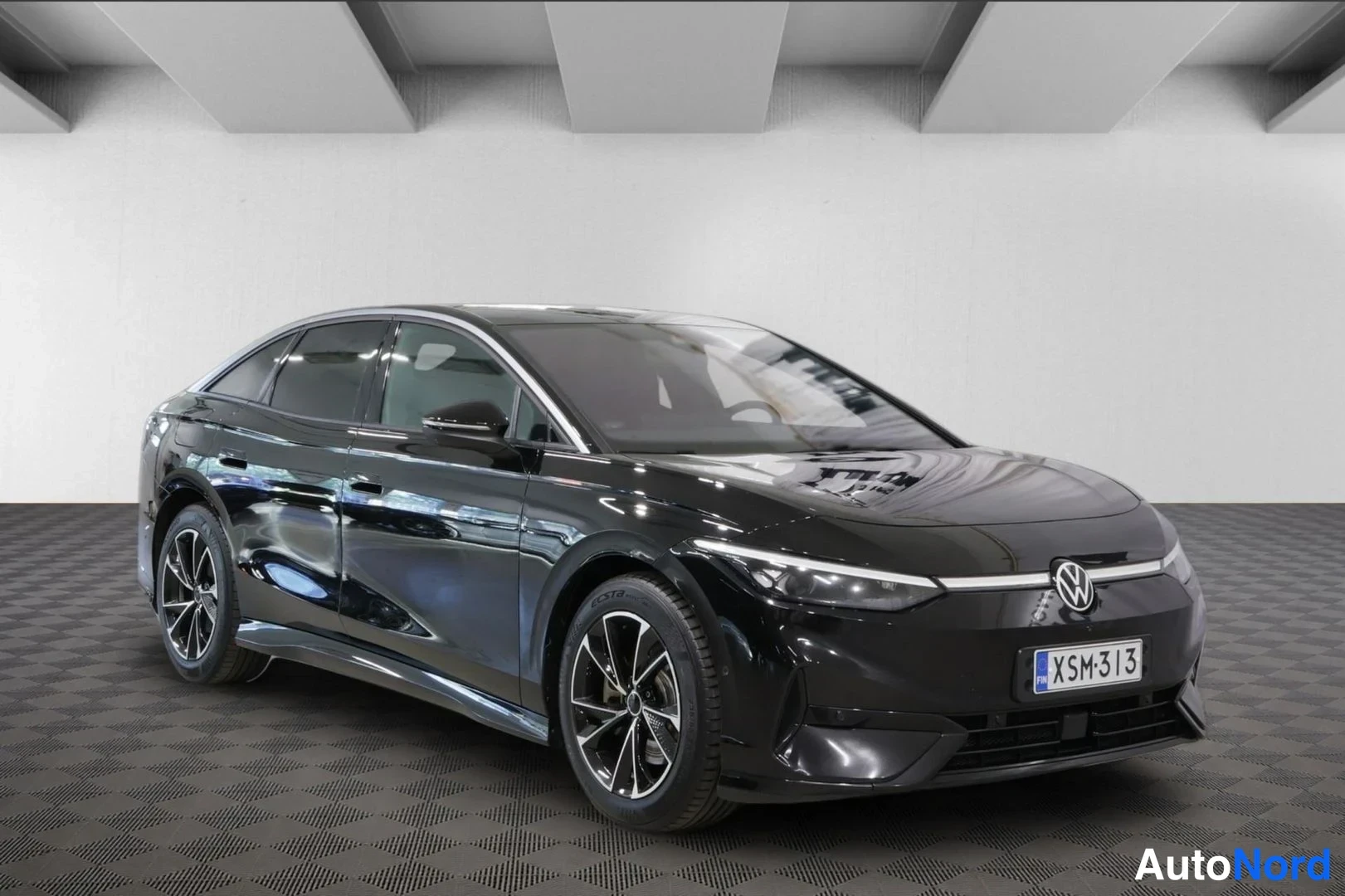 Etuviisto, nokka oikealle: Mustan Volkswagen ID.7:n etukulmanäkymä, keulakilpi, valoisassa studiossa.