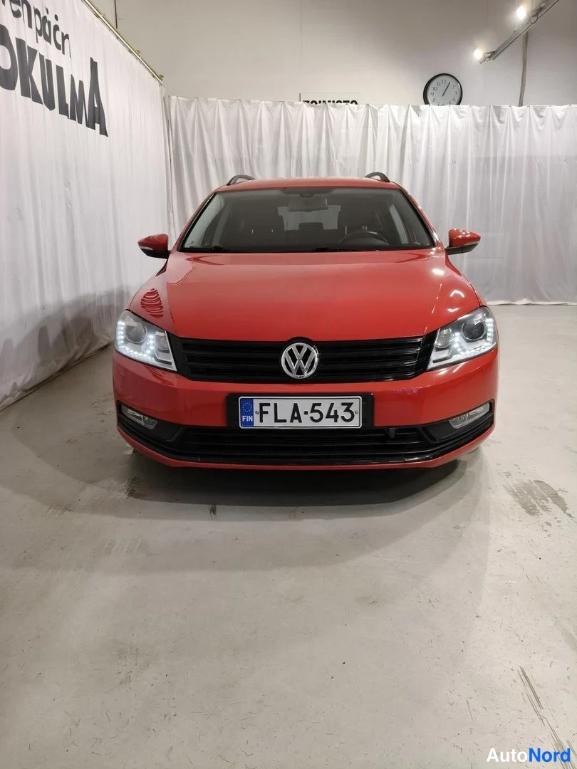 Edestä: Punaisen Volkswagenin suora etukuva sisätilassa, rekisterikilpi.