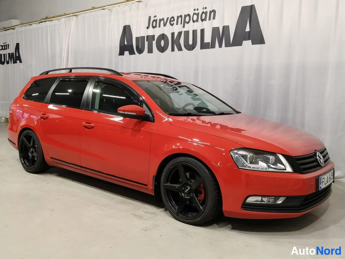 Etuviisto, nokka oikealle: Punainen farmari kolmesta edestä sivulta; mustat vanteet, punainen jarrusatula, kattokaiteet.