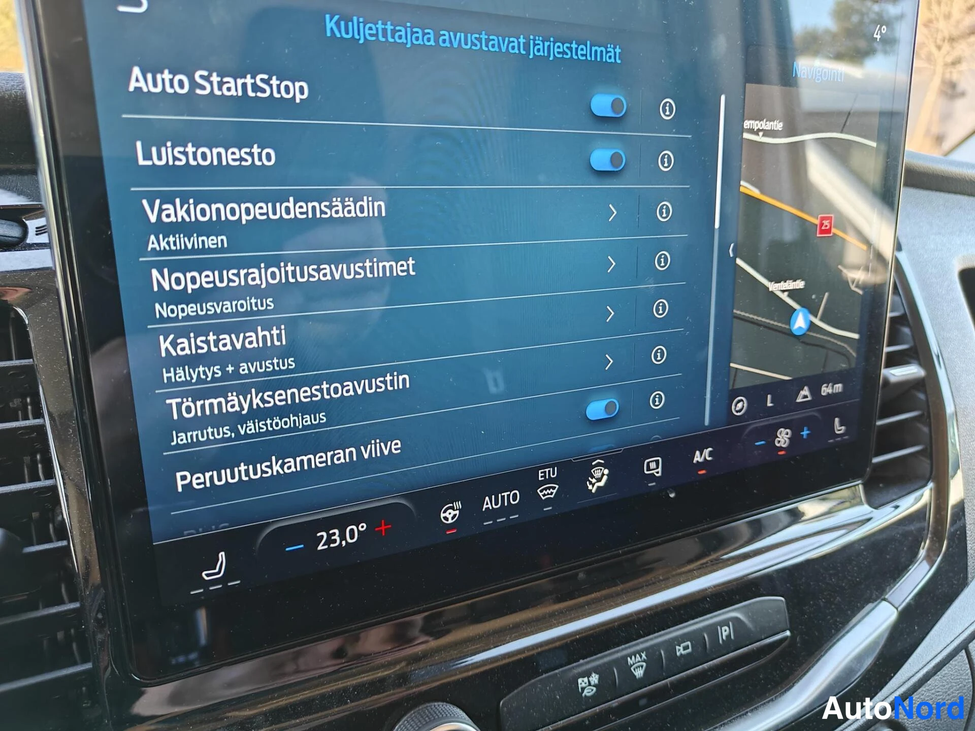 Yksityiskohta: Takin näytön kuljettajan avustejärjestelmien valikko: Auto StartStop, luistonesto, vakionopeudensäädin ja törmäyksenenestoavustin päällä.