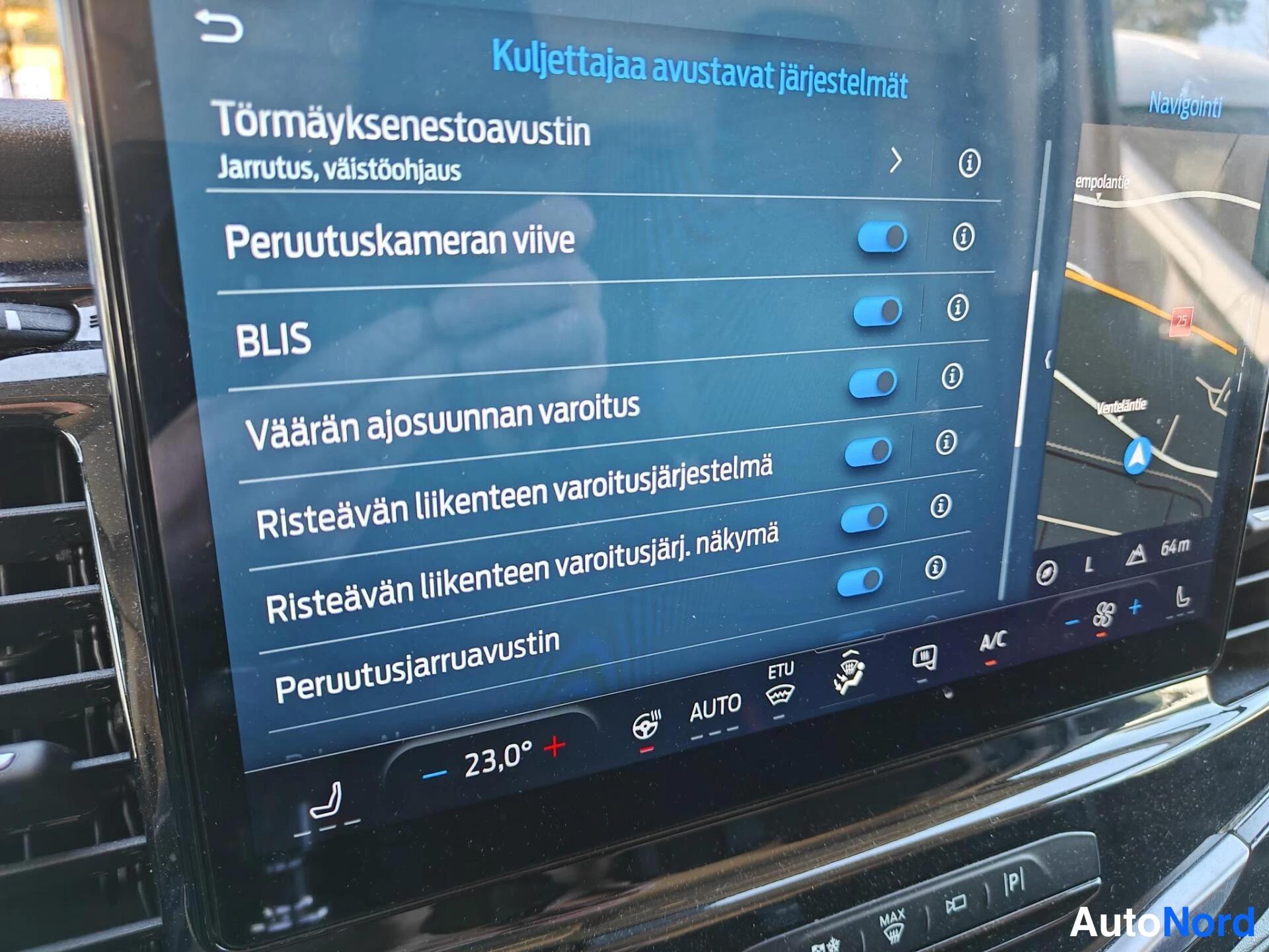 Yksityiskohta: Takin näytön avustejärjestelmävalikko: peruutuskameran viive, BLIS, väärän ajosuunnan varoitus ja risteävän liikenteen varoitus päällä.