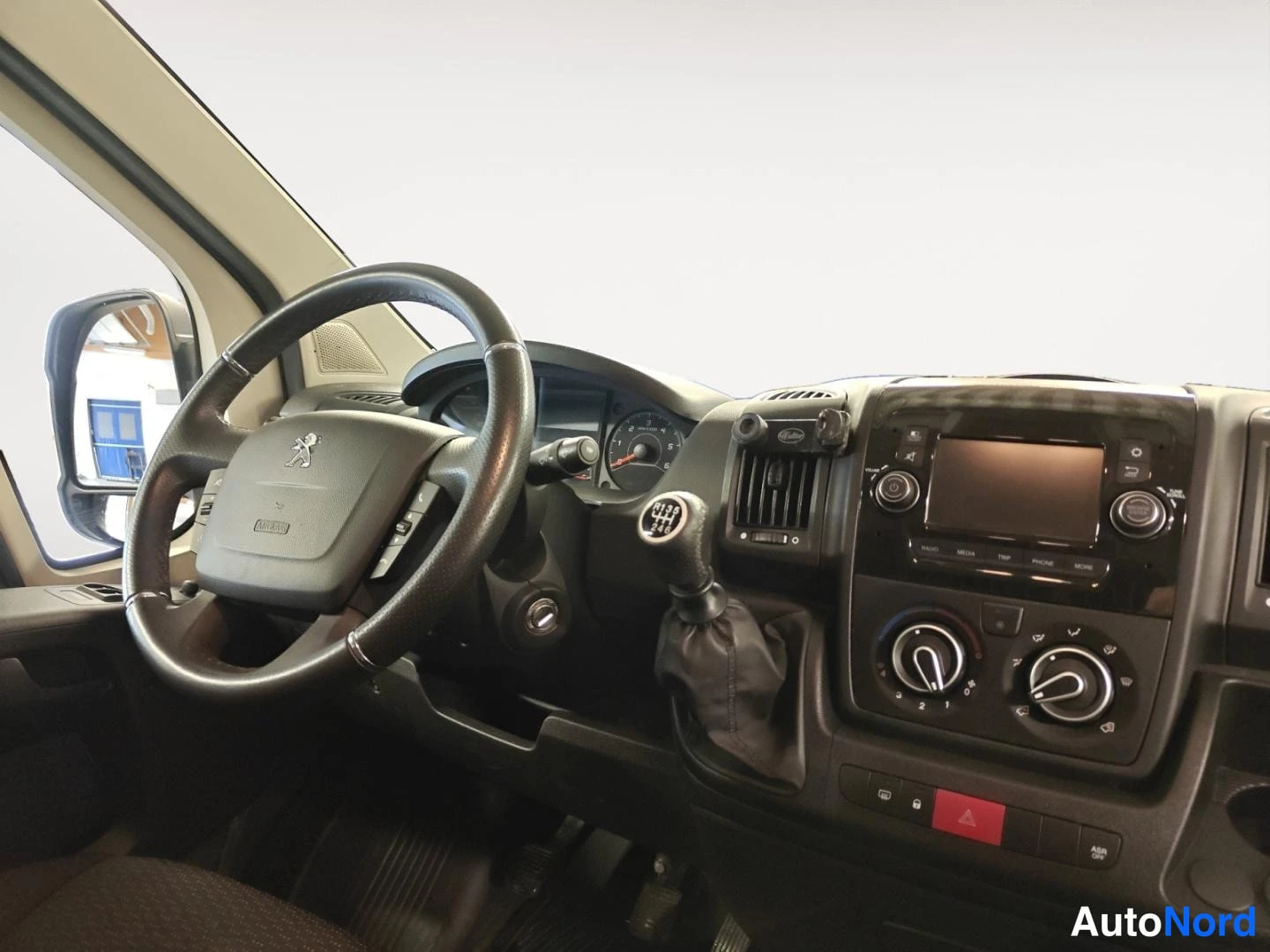 Muu: Ohjaamosta näkyy Peugeot-ohjauspyörä, manuaalivaihteiston vaihteenkeksi ja keskikonsolin radio.