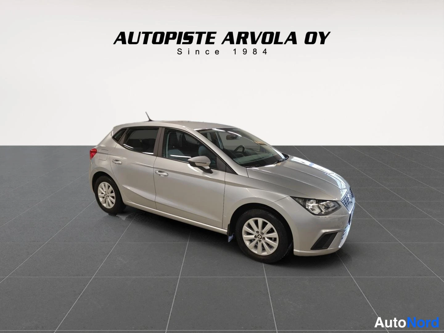 Etuviisto, nokka oikealle: Hopeanvärinen Seat Ibiza -viistoperä kuvattu kolmannelta etunurkalta autopesulassa.