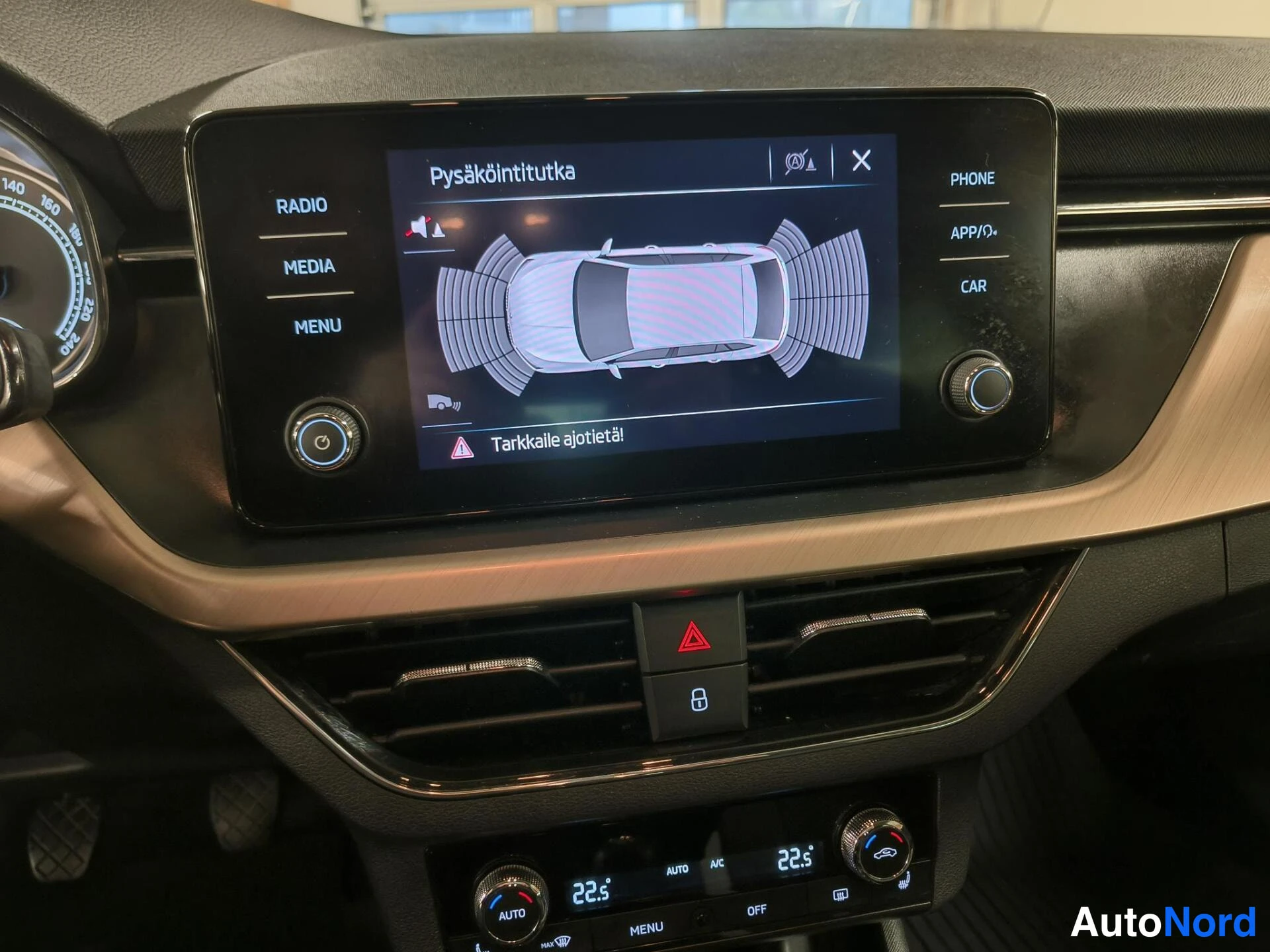 Muu: Infotainment-näyttö näyttää pysäköintitutkan grafiikan auton ympärillä; ilmastointipaneelissa lämpötila 22,5 asti.