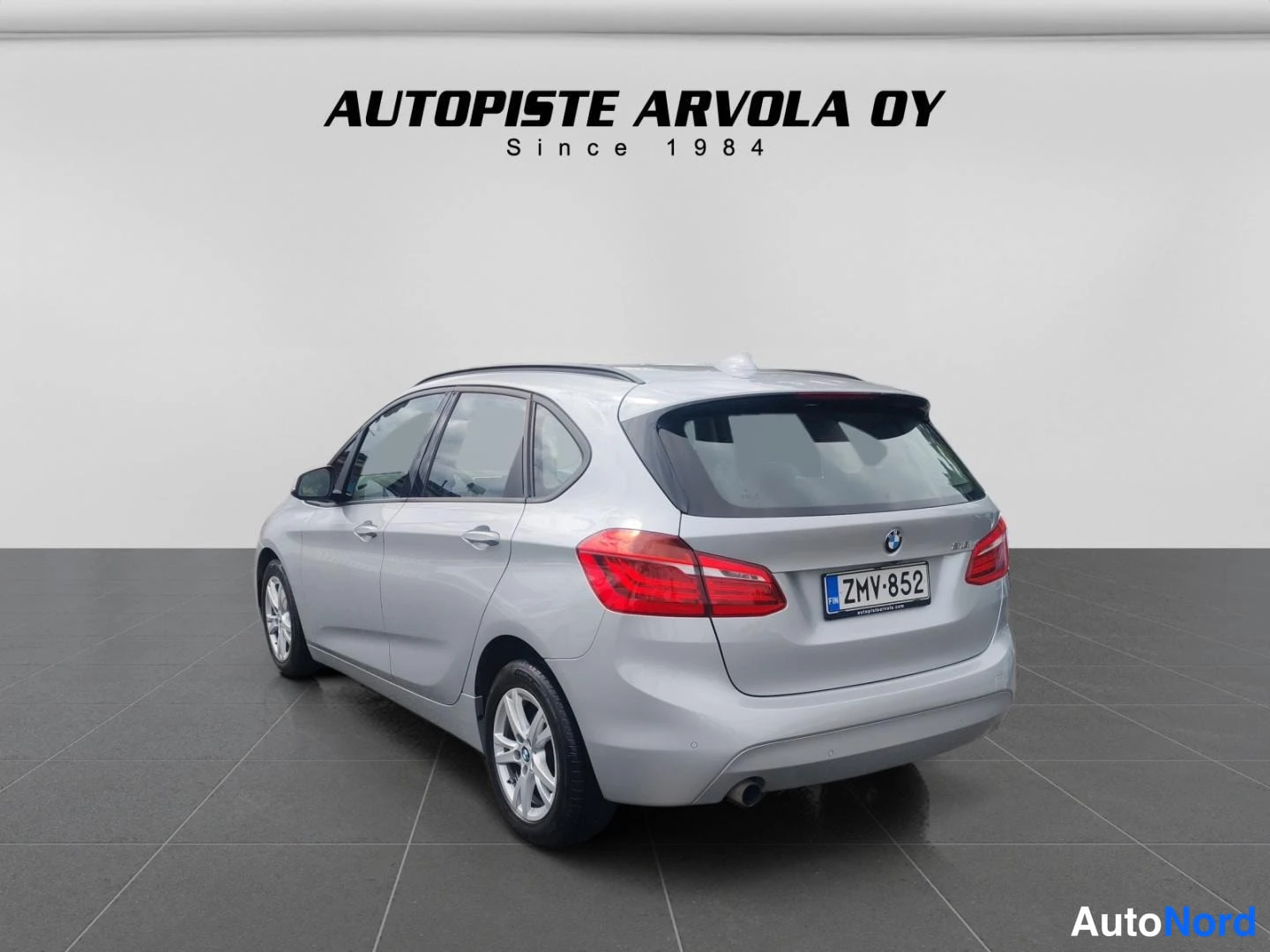 Takaviisto: BMW Active Tourer takaa oikealta, rekisterikilpi, hopeanhohtoinen koriväri.