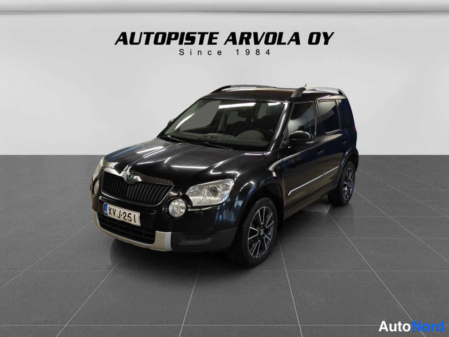 Etuviisto, nokka vasemmalle: Musta Skoda Yeti etu-vinosti kuvattuna sisätiloissa.