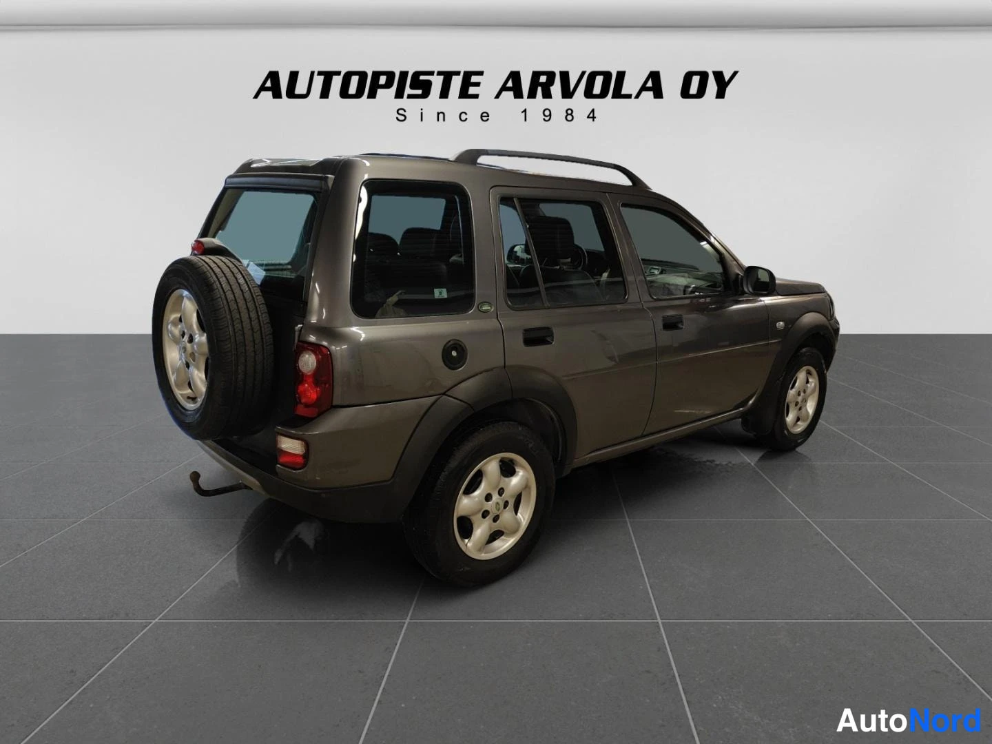 Takaviisto: Land Rover Freelander takaapäin oikealta kuvattuna, varapyörä takaluukussa ja kattokaiteet.