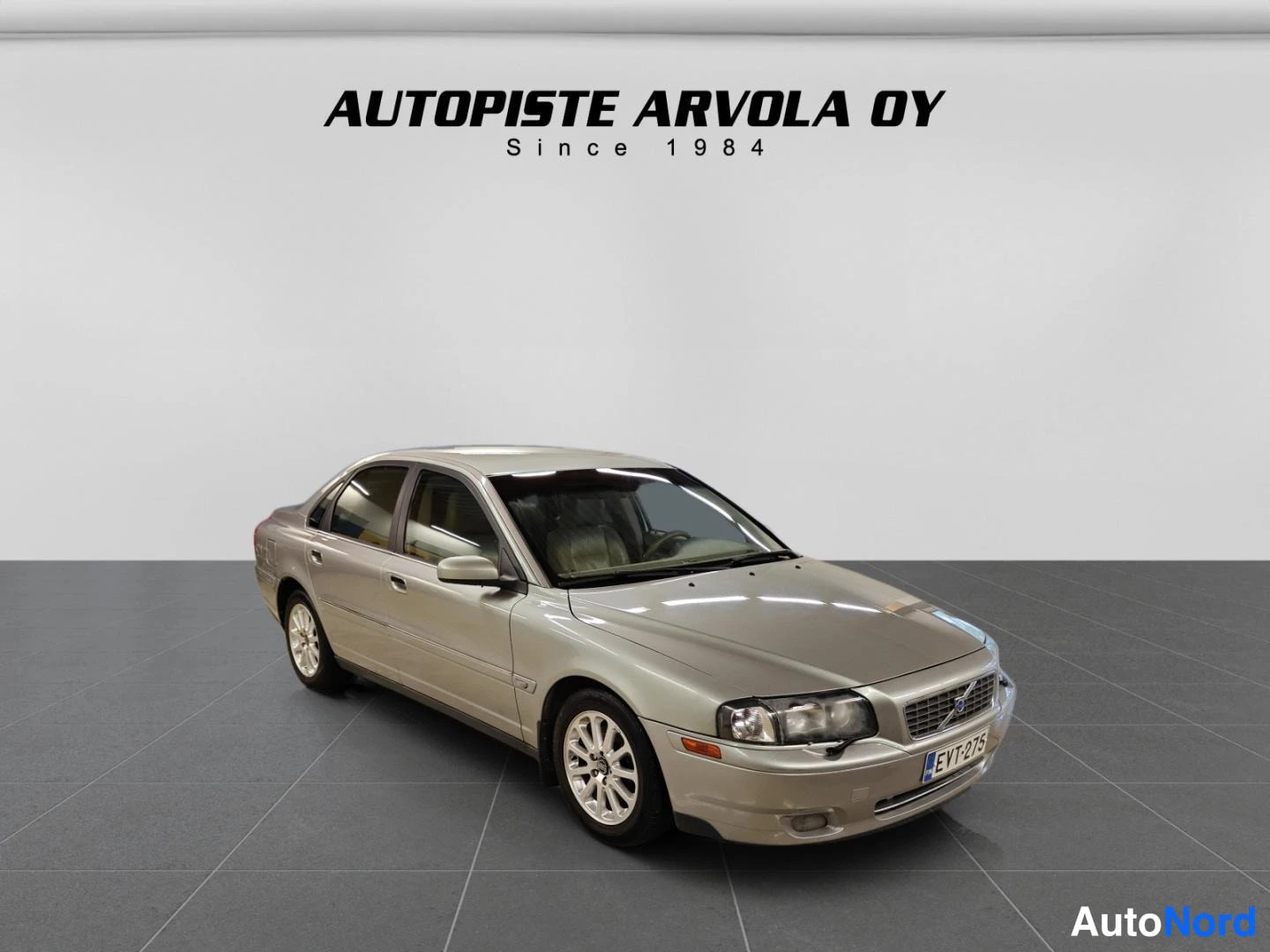 Etuviisto, nokka oikealle: Beige sedan autotallissa, etukulmanäkymä oikealta, rekisterikilpi.