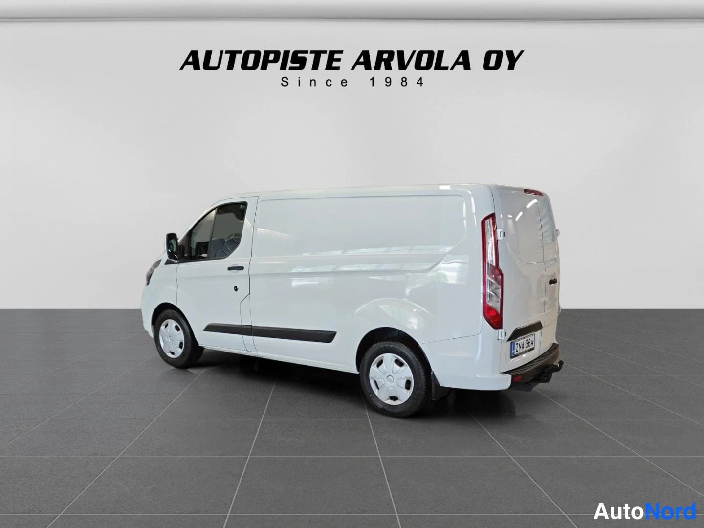 Takaviisto: Ford Transit Custom -pakettiauto valkoisena takaa oikealta kuvattuna.