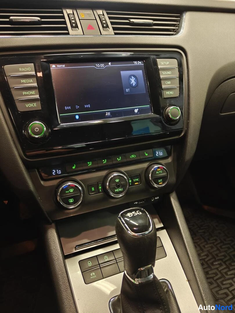 Muu: Keskikonsoli, jolla radio/navigointiyksikkö näyttää Bluetooth-valikkoa, ilmastointipaneelin AUTO-, A/C- ja SYNC-painikkeet sekä DSG-merkitty automaattivaihteist