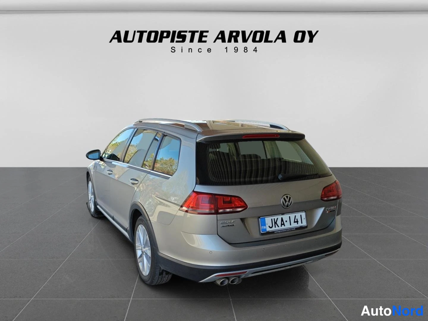 Takaa: Volkswagen Golf Variant takaa sivulta kuvattuna studiossa, hopeanbeige autti, rekisterikilpi, AUTUPISTE ARVOLA OY logo taustalla.