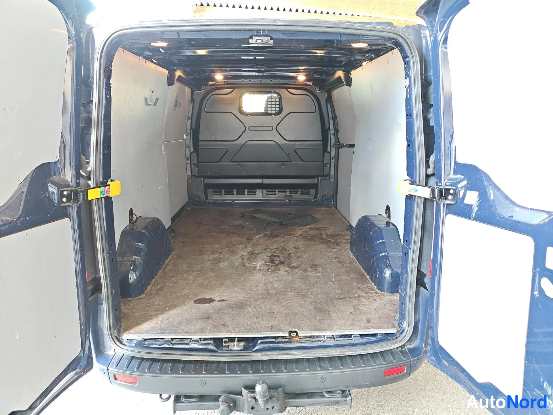 Takaistuimet: Ford Transit Customin tavaratila takaovilta: puisiainen, eristetyt seinät, kattovälineistö ja vetokoukku.