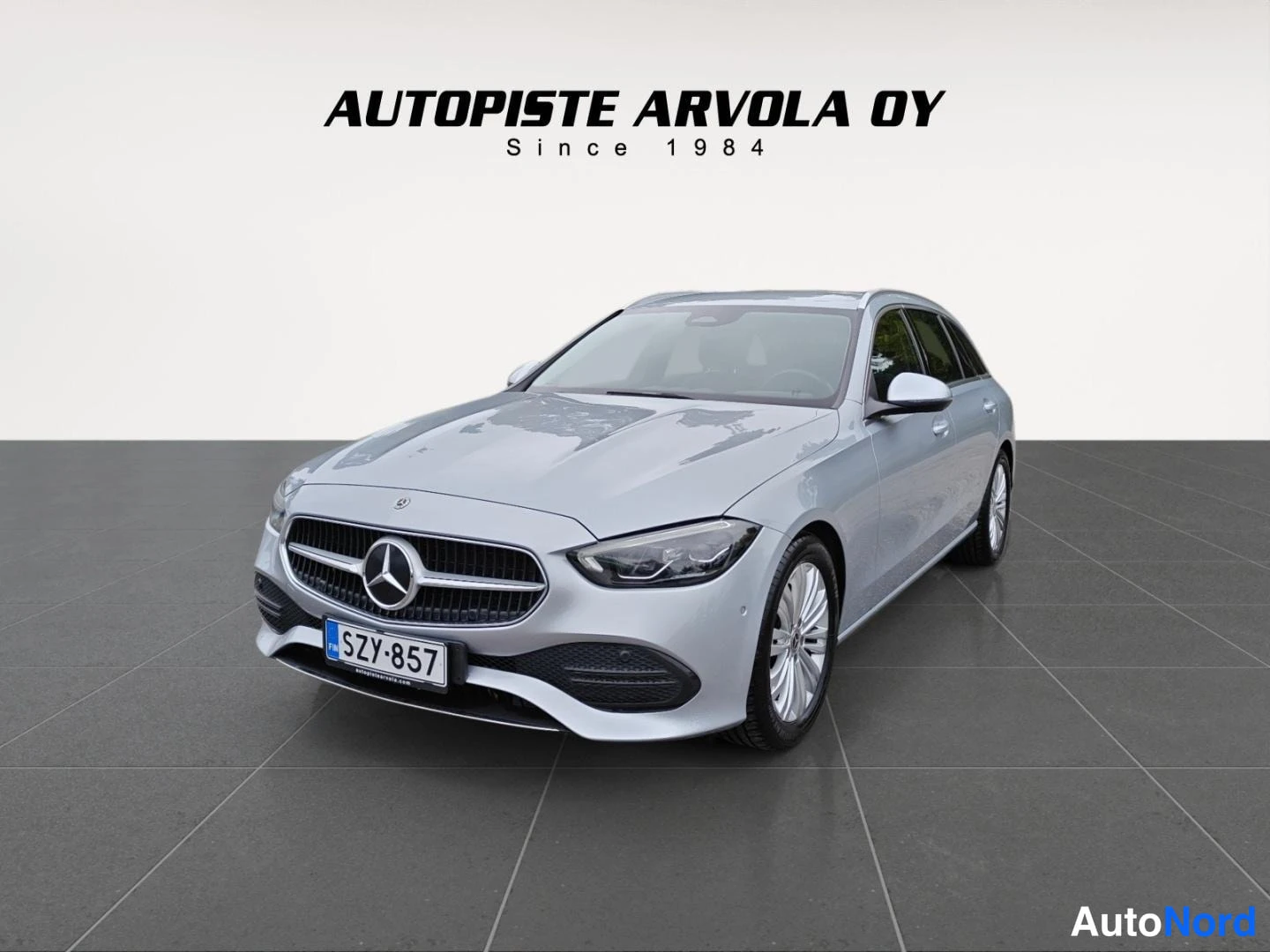 Etuviisto, nokka vasemmalle: Mercedes-Benz C farmari etukulmasta vasemmalta, hopeanvärinen, rekisteritunnus