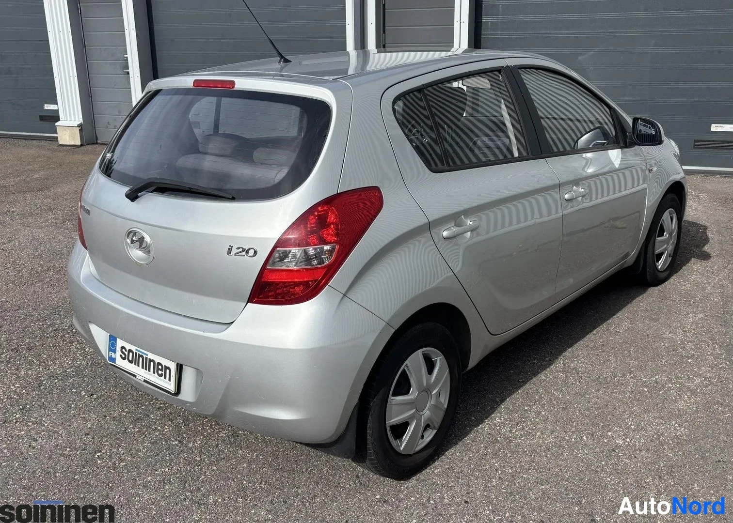 Takaviisto: Hyundai i20, hopea, vinosti takaa vasemmalta kuvattu, i20-merkintä takaluukussa