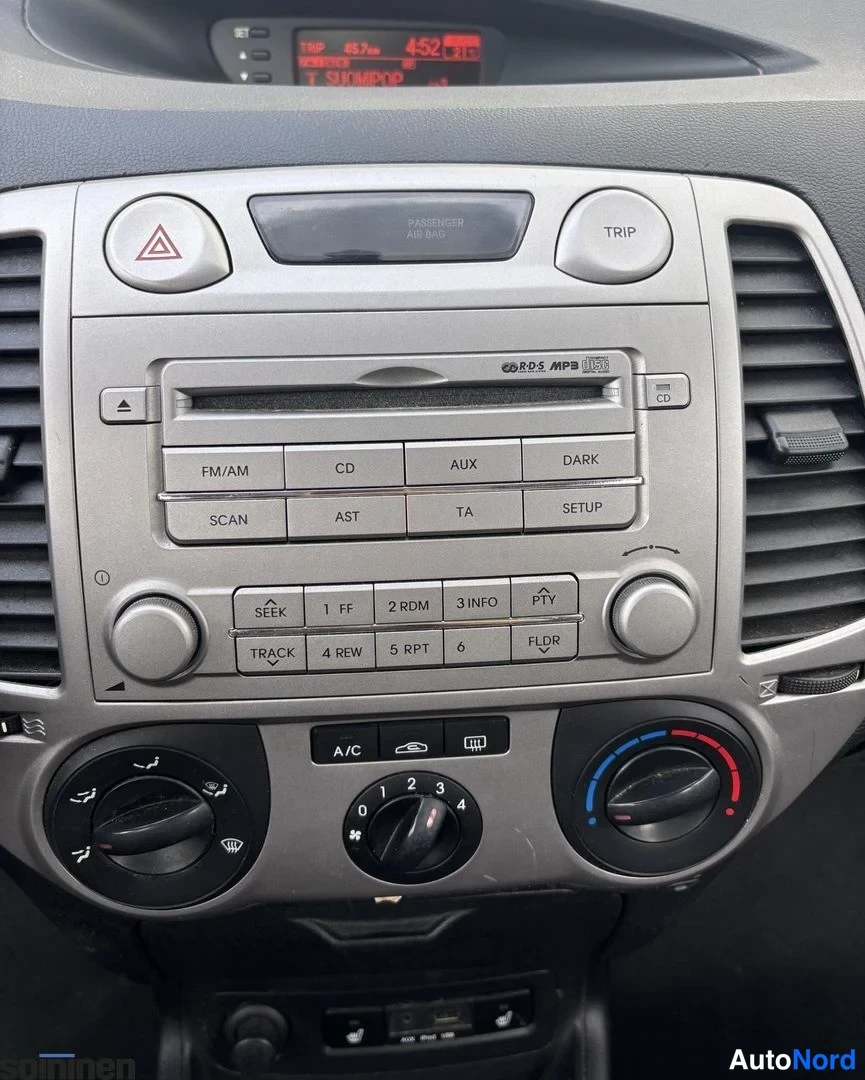 Yksityiskohta: Keskikonsoli: radio-CD-soitin AUX- ja USB-liitännöillä sekä manuaali-ilmastointi (A/C).