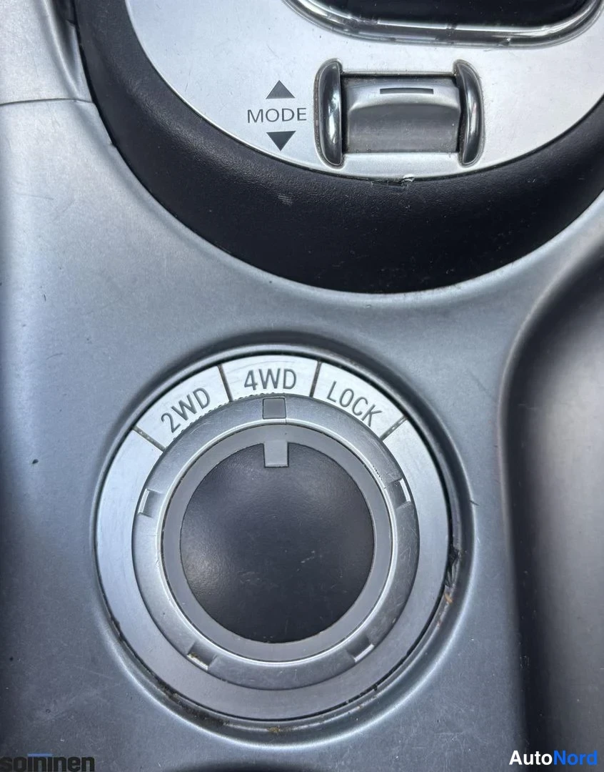 Muu: auton keskikonsolin ajotilavalitsin, jonka asennot ovat 2WD, 4WD ja LOCK, sekä MODE-merkitty liukusäädin.