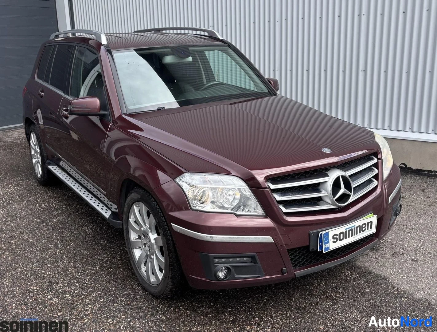 Etuviisto, nokka oikealle: Etusivu ja oikea sivu Mercedes-Benz GLK, punaruskean runkoon varustettu katto- ja sivupakilla. Alumiinivanteet näkyvät edessä.