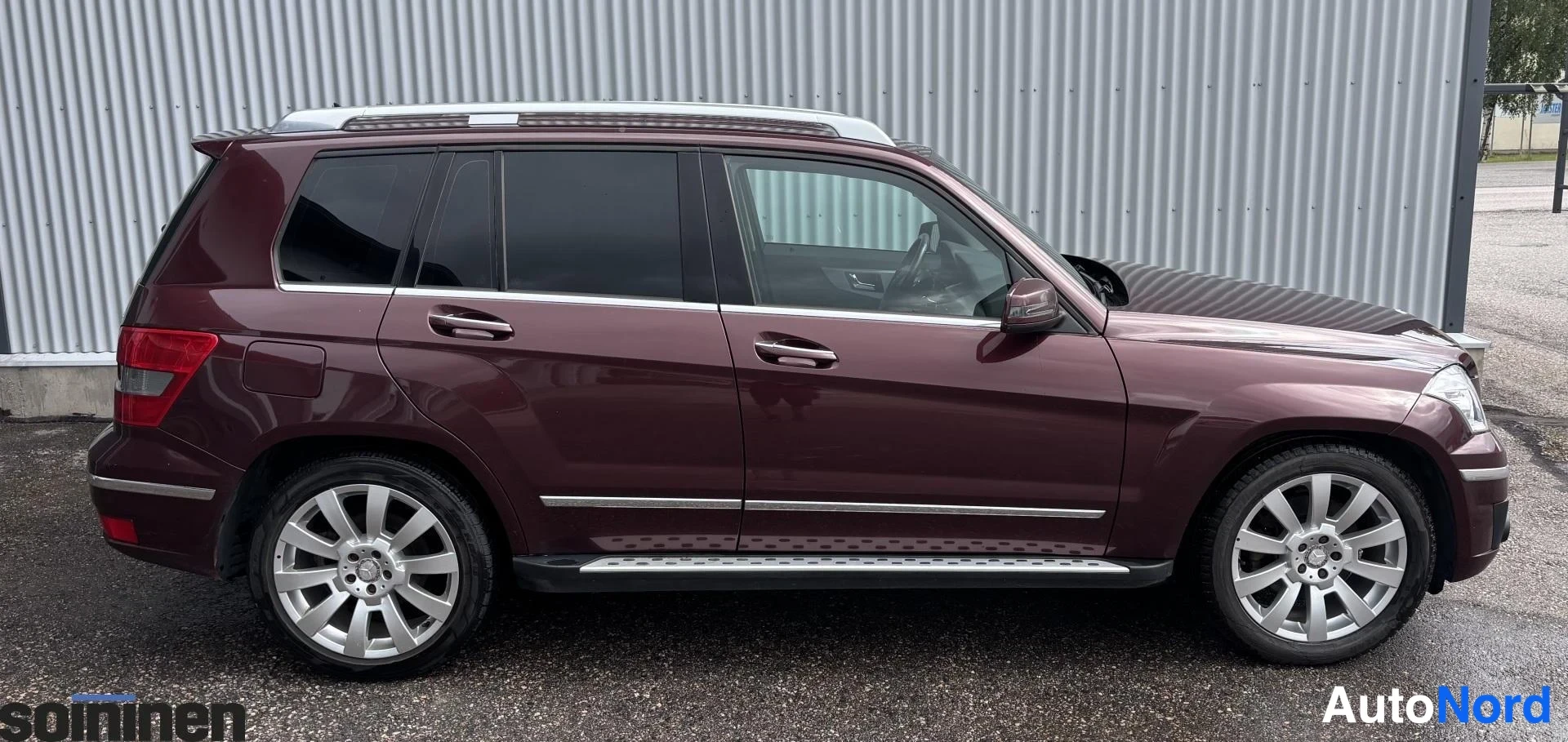 Takaviisto: Mercedes-Benz GLK:n kylki- ja peräosakuva: tummanpunainen koripaneeli, takavalot, kattokaiteet ja hopeiset astinlaudat.