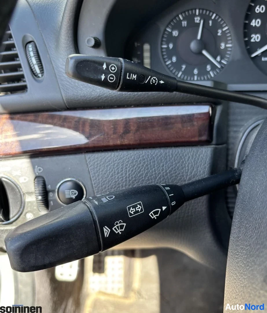 Muu: Ohjauspyörän vaihtimet ja 추iomerkkivivu Mercedes-Benzin ohjaamossa, taustalla osa mittaristosta.