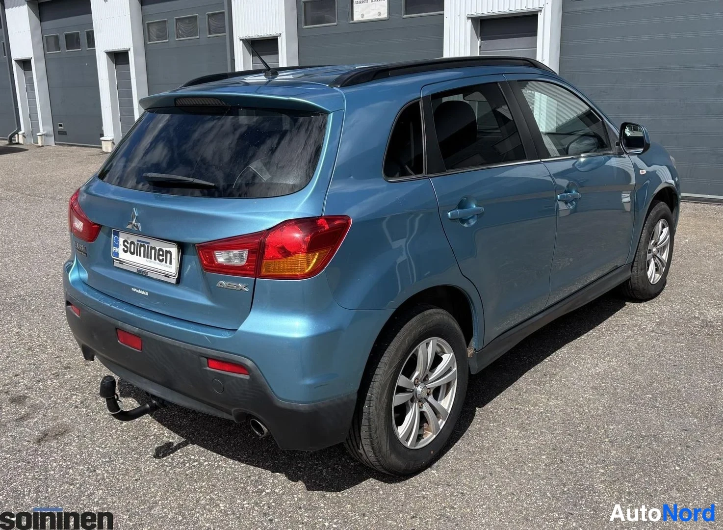 Takaviisto: Takakulma-kuvia sinivihreästä Mitsubishi ASX -korkeatila-autosta; takapää ja auton oikea sivu näkyvät samassa ruudussa. Etuviput ja rekisterikilvi-soininenn ova