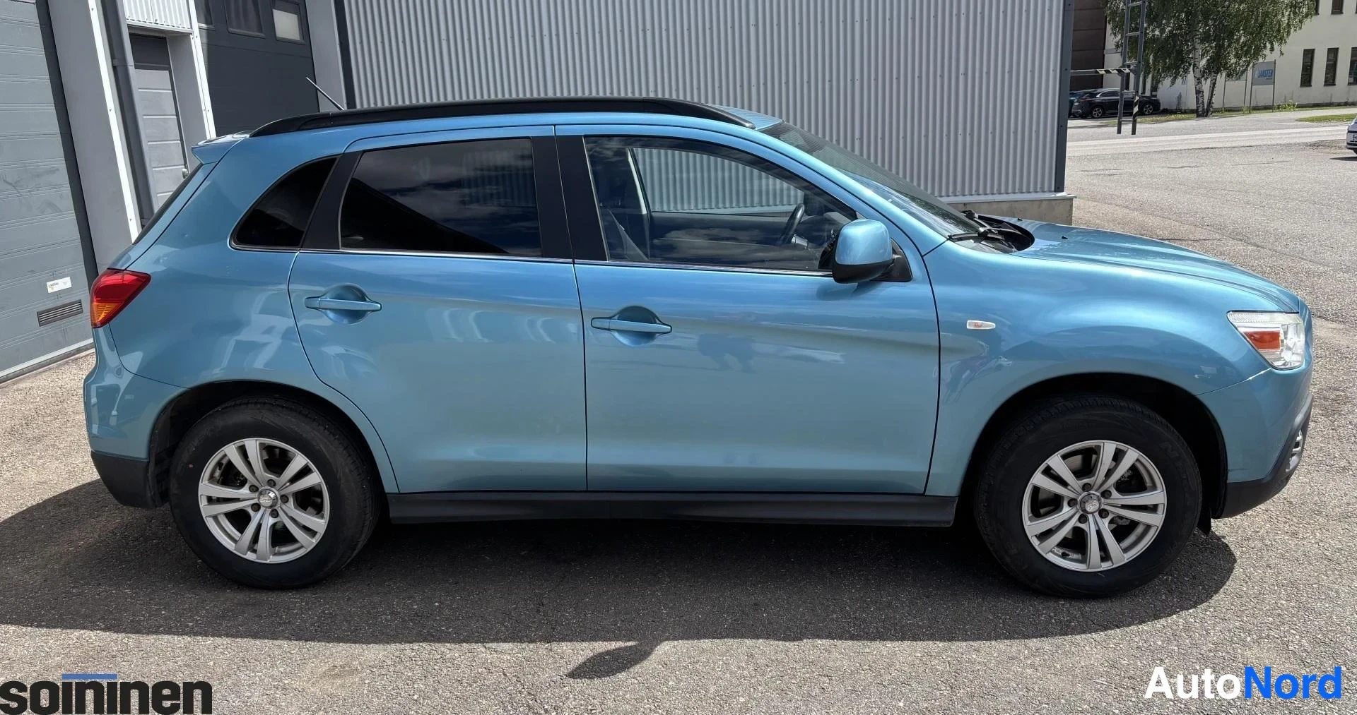 Etuviisto, nokka oikealle: Sininen Mitsubishi ASX -farmariauto sivulta etukulmasta, etusäleikkö kuvan oikeassa laidassa.