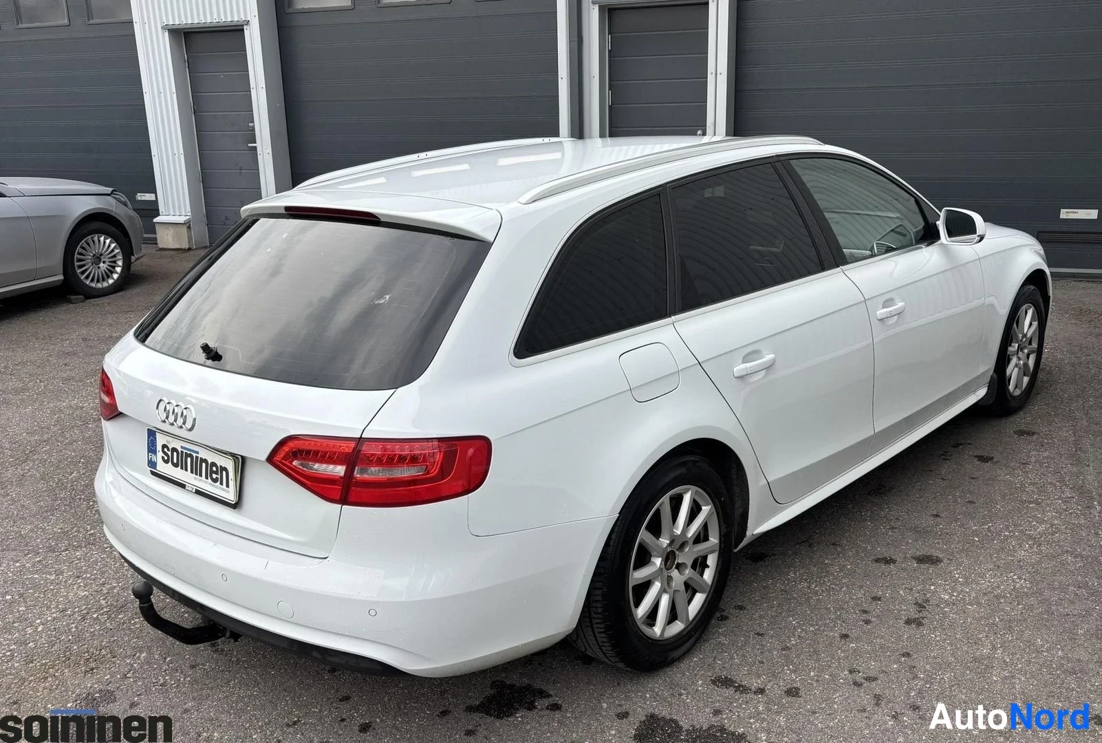 Takaviisto: Valkoinen Audi A4 Avant kuvattuna takaa oikealta. Takaluukku, taivalaitos ja oikea sivu ovat selvästi näkyvissä.