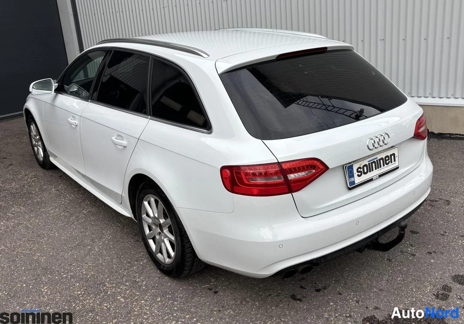 Takaviisto: Valkoinen Audi A4 Avant kuvattuna takaa vasemmalta. Takaluukku, taivalaitos ja vasen sivu ovat selvästi näkyvissä.