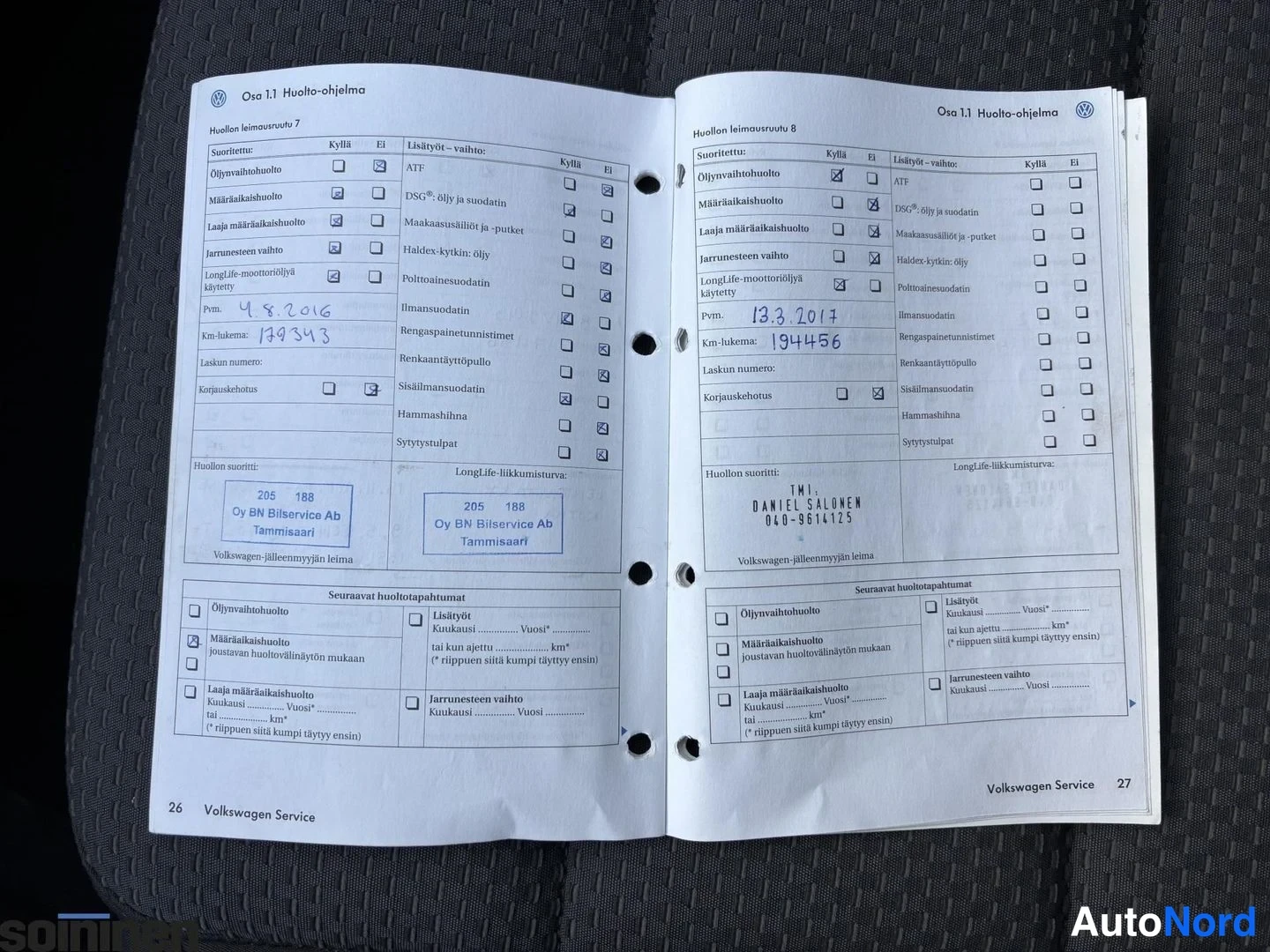 Muu: Volkswagen-huoltokirjan sivut 26–27 avattuna huoltokirjamerkinnöillä.