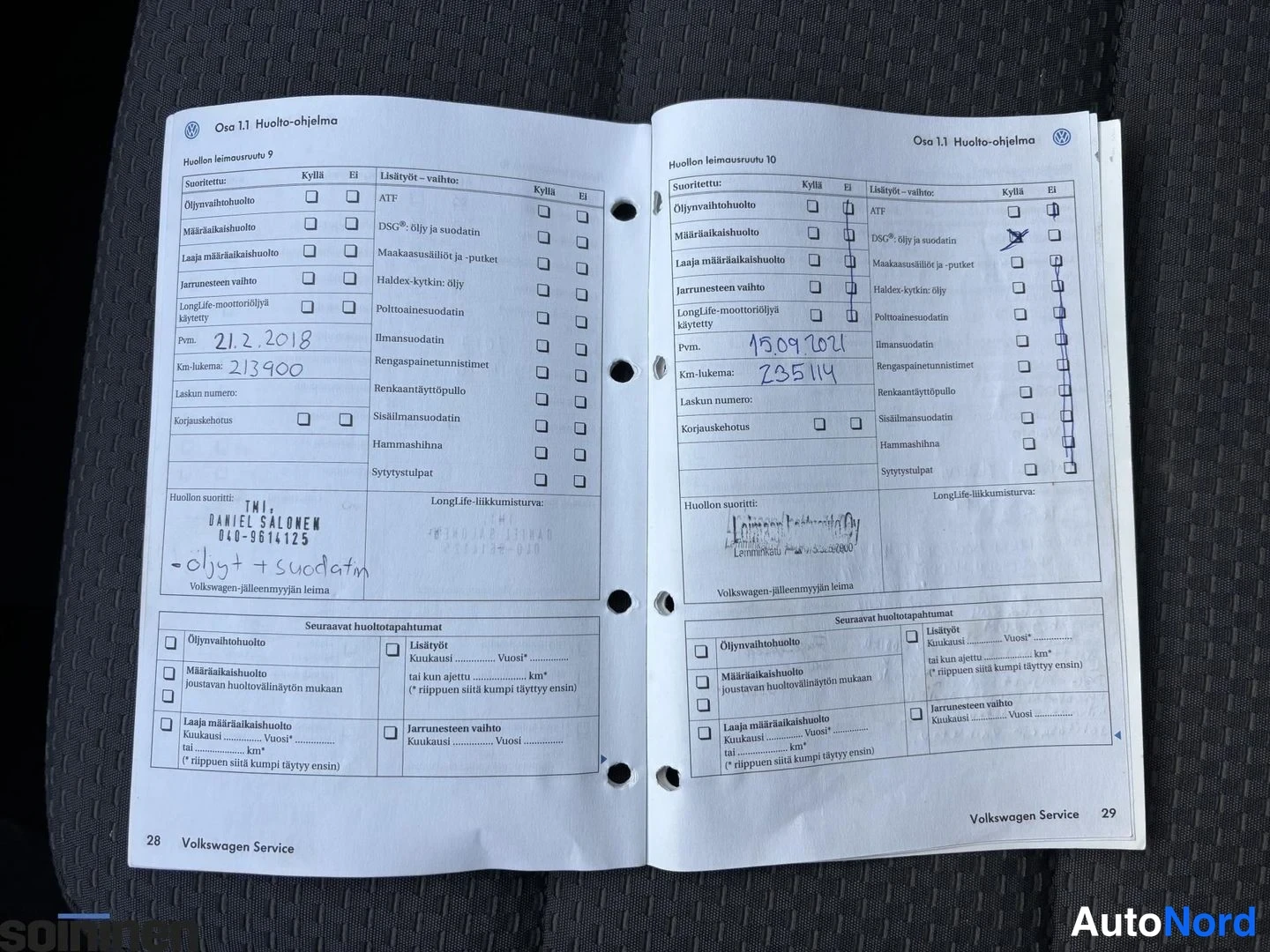 Muu: Volkswagen-huoltokirjan sivut 28–29 avattuna huoltokirjamerkinnöillä.
