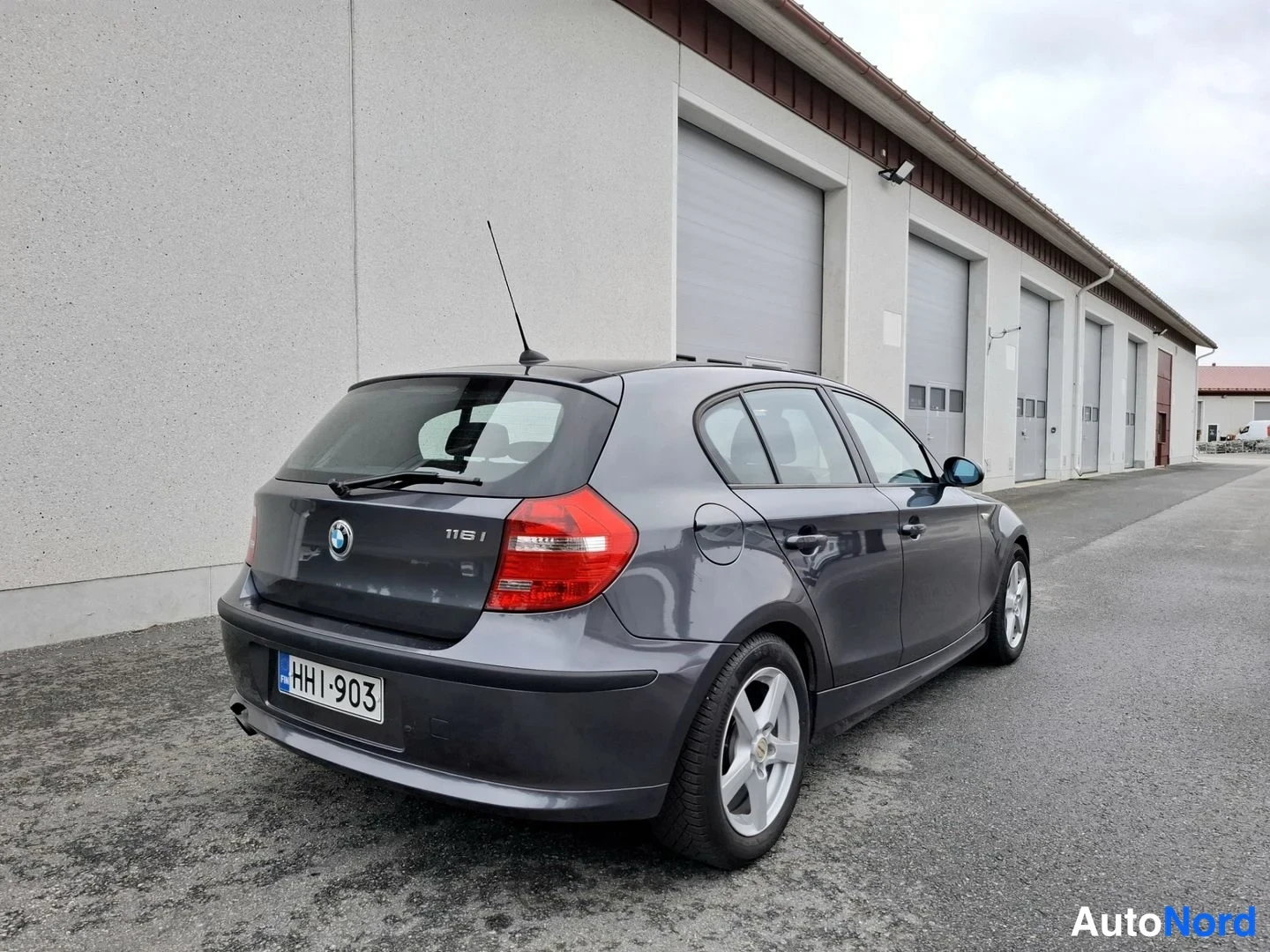 Takaviisto: BMW 1-sarjan viistoperän takaosa ja sivu takaa vasemmalta kuvattuna, rekisteri HH I-903.