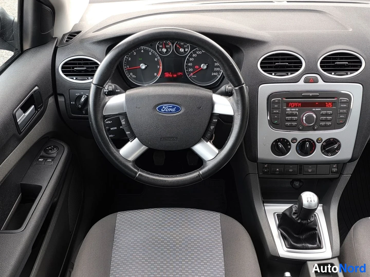 Asiakirja: Kuljettajan näkymä Ford Focusissa: Ford-merkkinen ohjauspyörä, mittaristo ja keskikonsolin radio sekä manuaalivaihteen vipu.