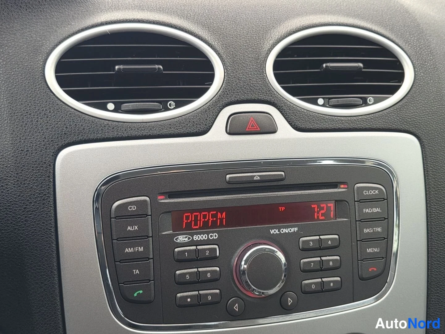 Muu: Ford 6000 CD -radiosoitin kojelaudassa, näytöllä POPFM ja kello 7:27.