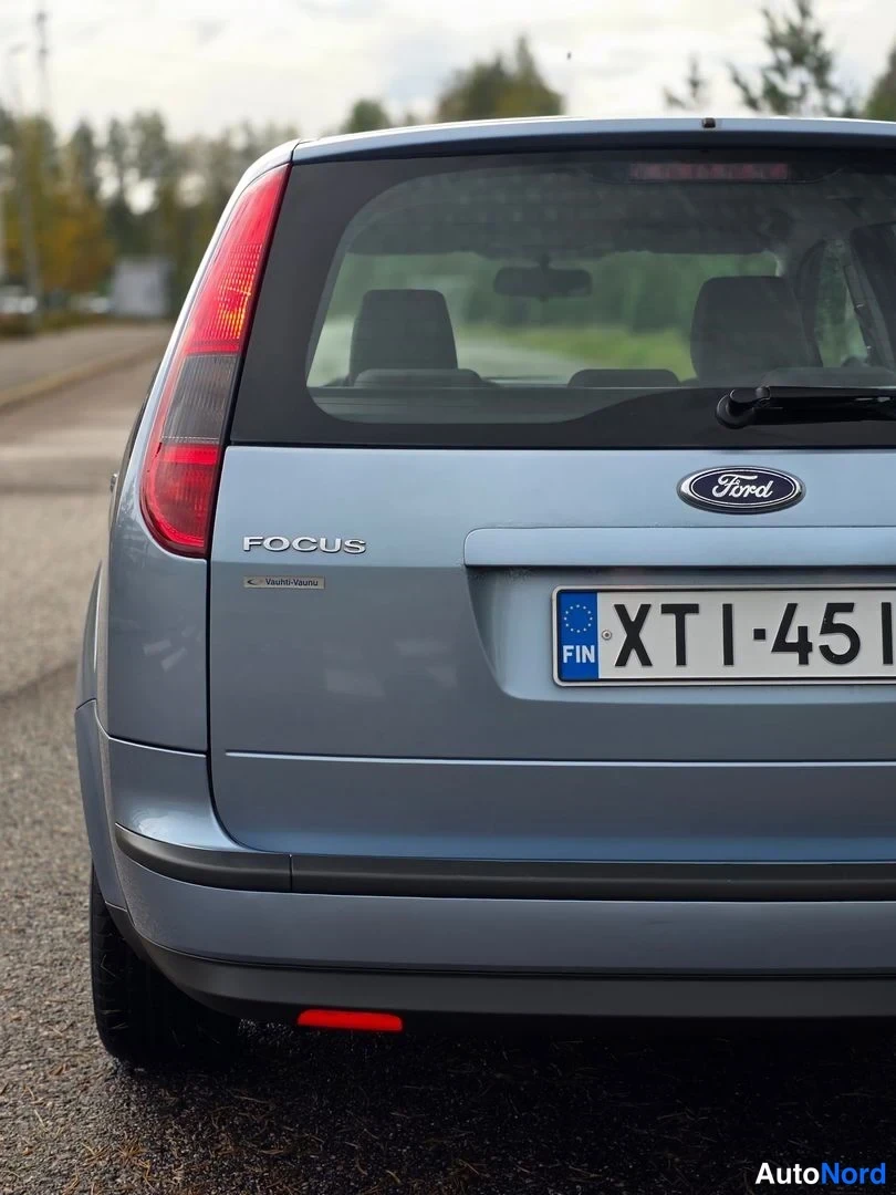 Takaa: Ford Focuksen takanäkymä: sinertävänharmaa koripaneeli, FOCUS-teksti, Ford-tunnus ja suomalainen rekisterikilpi.