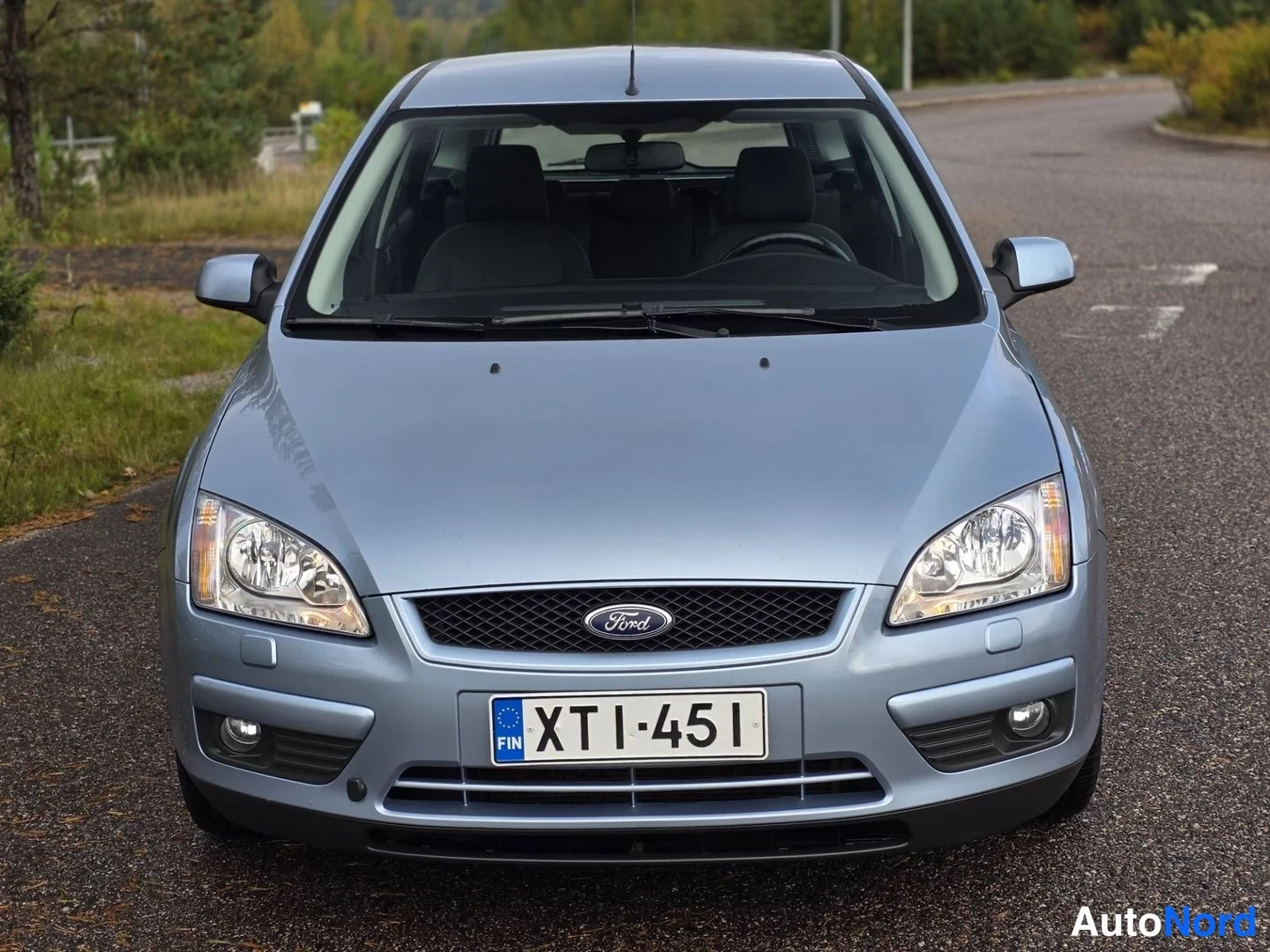 Edestä: Ford Focus suoraan edestäpäin, harmaansininen kori, etumoottoritilan etusarvi, sumuvalot ja rekisterikilpi.