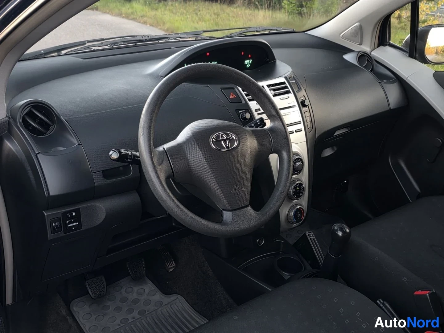 Muu: Toyota Yariksen kojelauta ja ohjauspyörä kuljettajan puolelta vasemmalta kuvattuna.