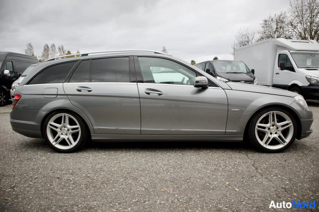Sivulta: Hopeanharmaa Mercedes-Benz -farmari sivulta, viisitoista tuuman hopeat kevytmetallivanteet.