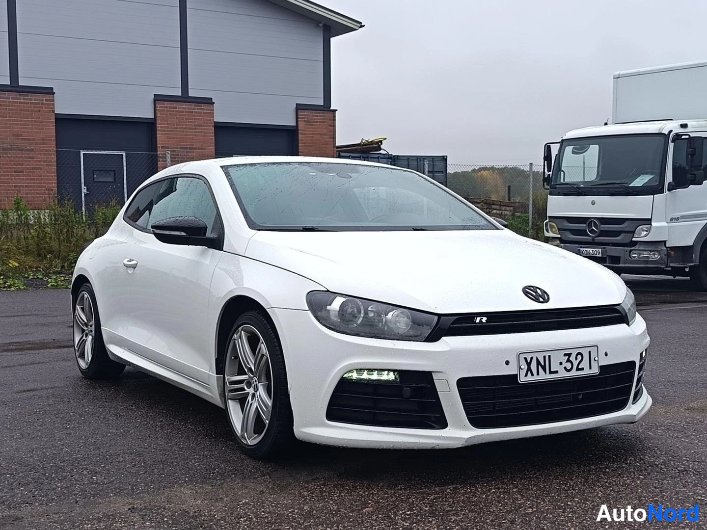 Etuviisto, nokka oikealle: Valkoinen Volkswagen Scirocco kolmesta neljänneksestä edestä oikealta kuvattuna, rekisteritunnus.