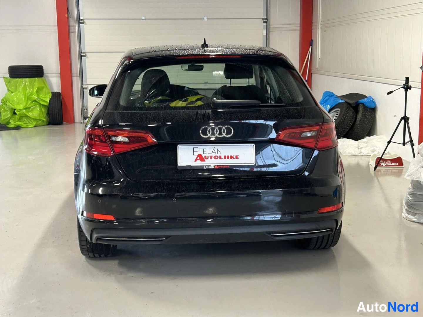 Takaa: Mustan Audi A3 Sportbackin suora takanäkymä, Audi-renkaat-kuvake ja Etelän Autoliike -kyltti rekisterikilven paikalla.