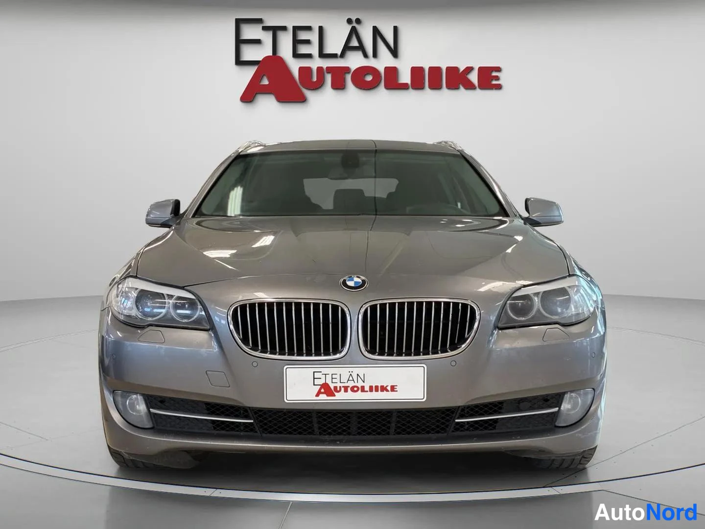 Edestä: Straight front view of a grey BMW station wagon.