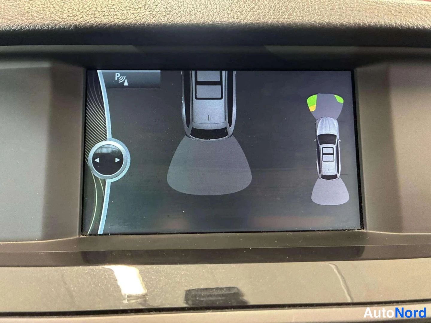 Yksityiskohta: Auton näyttö, jossa pysäköintiantureiden ja 360-kameran kuva.