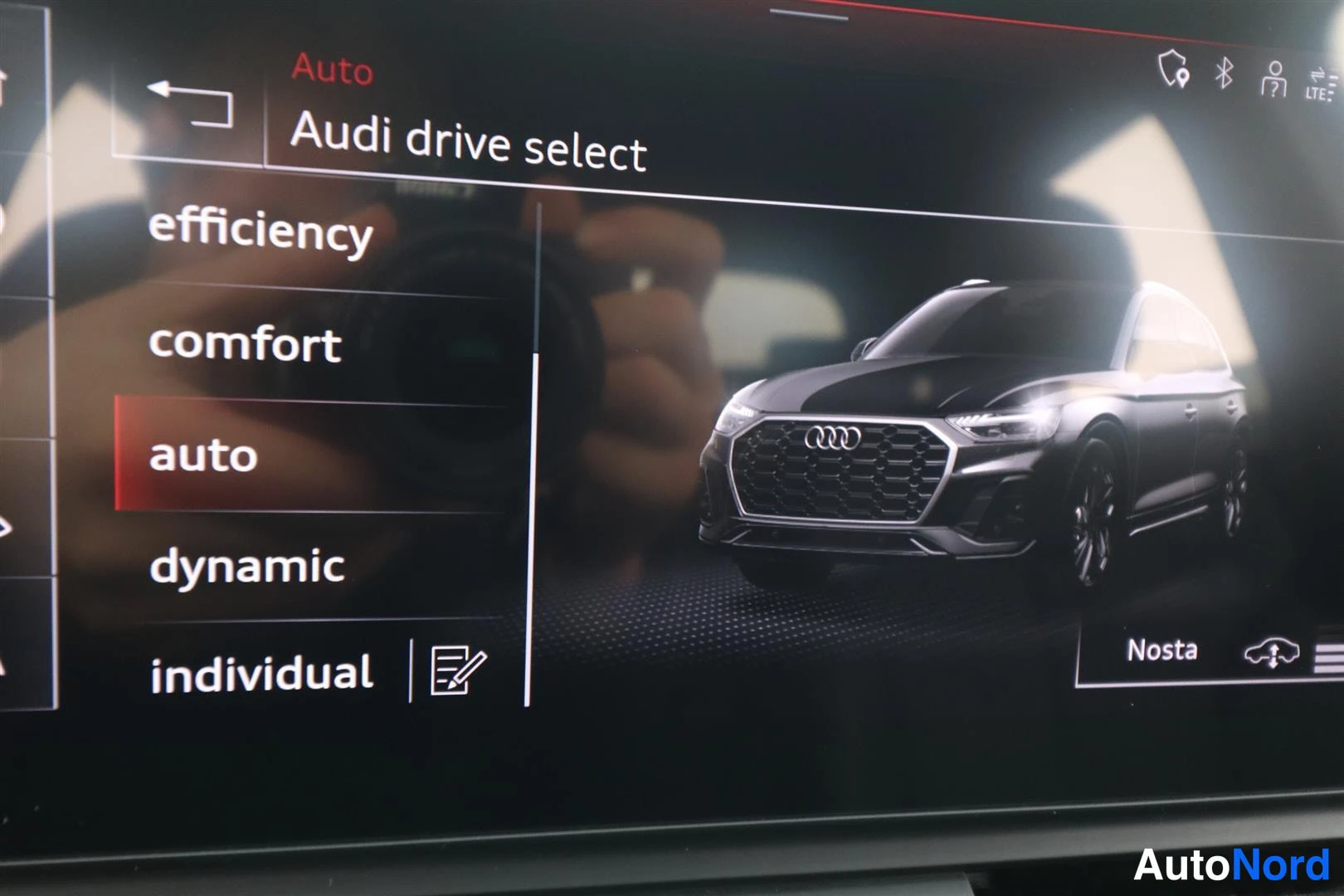 Ohjaamo: Näyttö ruudussa valitaan eri ajotilaa: 'efficiency', 'comfort', 'auto', 'dynamic', ja 'individual'. Ruudun oikealla puolella on pienoiskuva mustasta autosta, jo