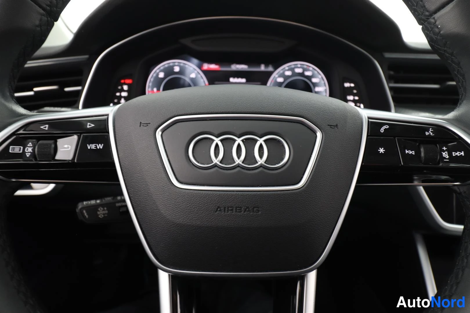 Yksityiskohta: Ohjaustehas ja mittaristo; Audi-logo ja AIRBAG-teksti ohjauspyörässä.