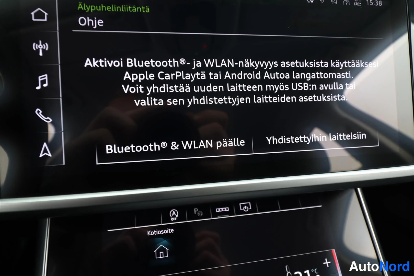 Etuviisto, nokka oikealle: Tallenne: Kokenut kuljettaja hymyilee ohjauspyörän äärellä vihreässä maasturissa, metsätausta sumuverhon takana.