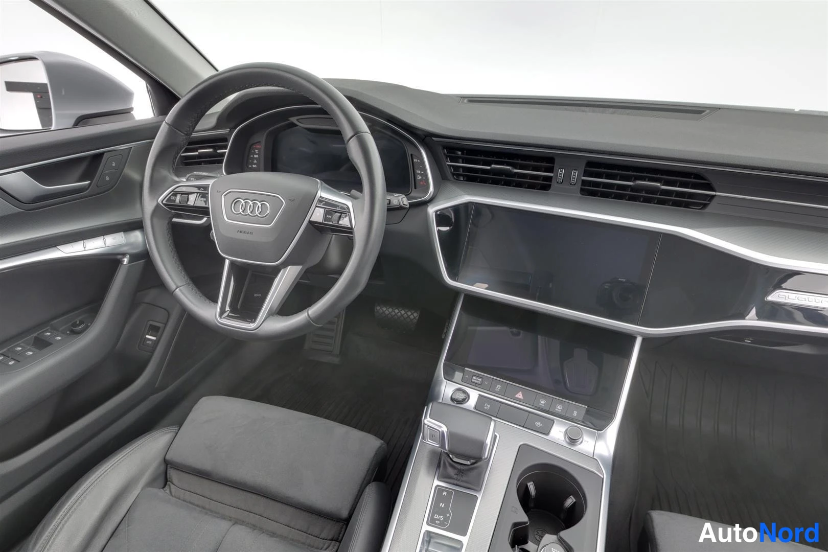 Muu: Kuljettajan puolen näkymä: Audi-ohjauspyörä, digitaalinen mittaristo ja keskikonsoli vaihteenvalitsimella.