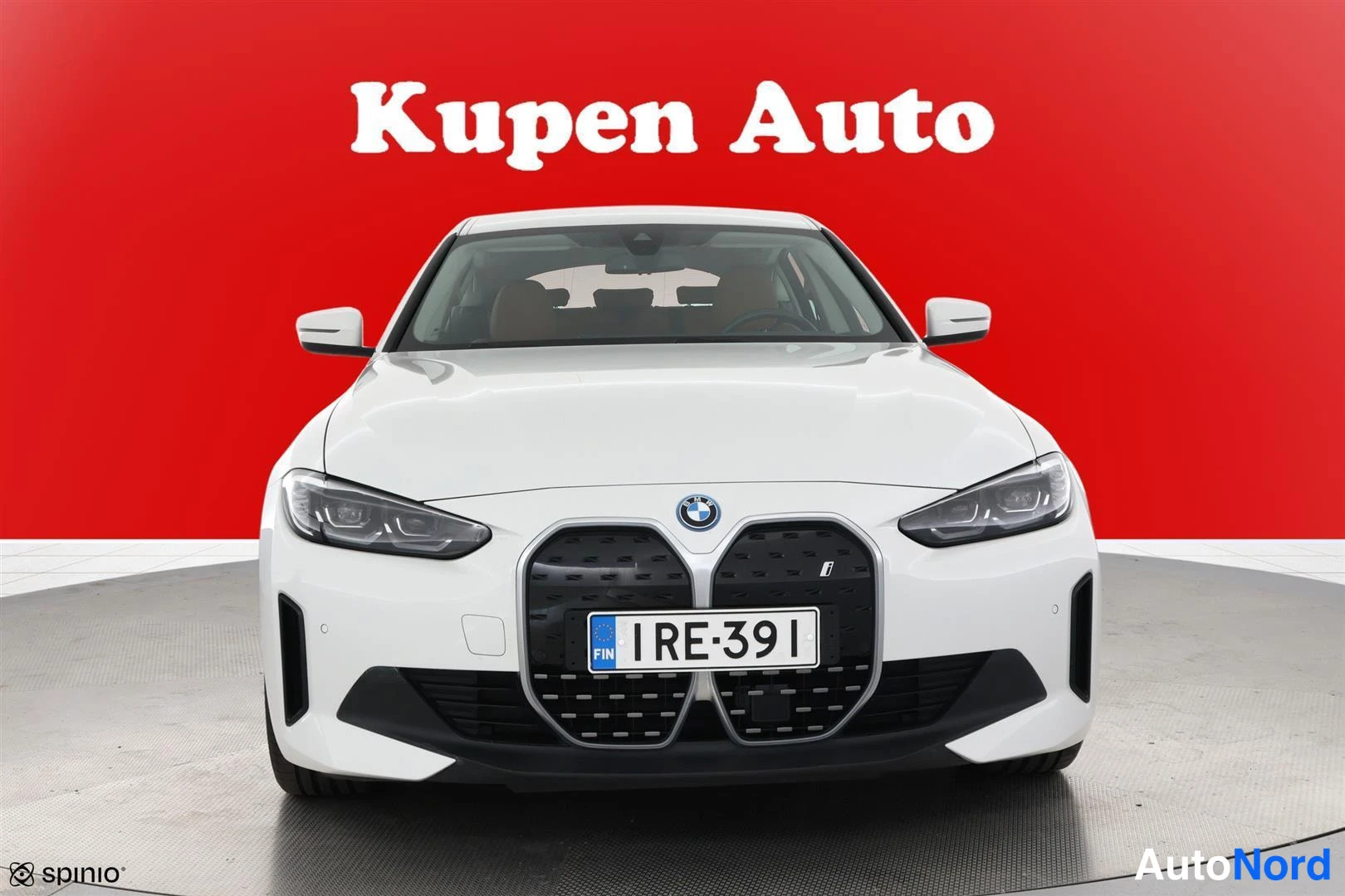 Edestä: Suora etukuva valkoisesta autosta, jossa on suuri grilla ja BMW-logo keskellä.