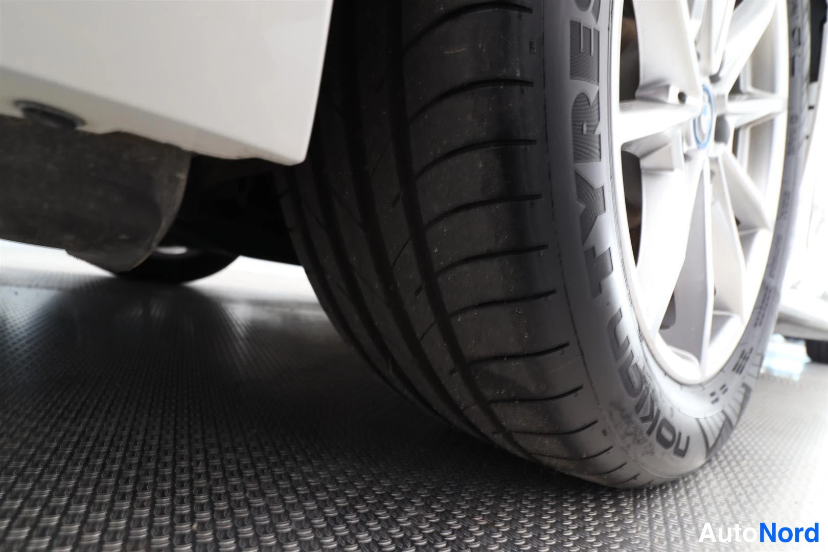 Yksityiskohta: Etupyörän close-up: Nokian Tyres -rengas ja hopeanvärinen vanne